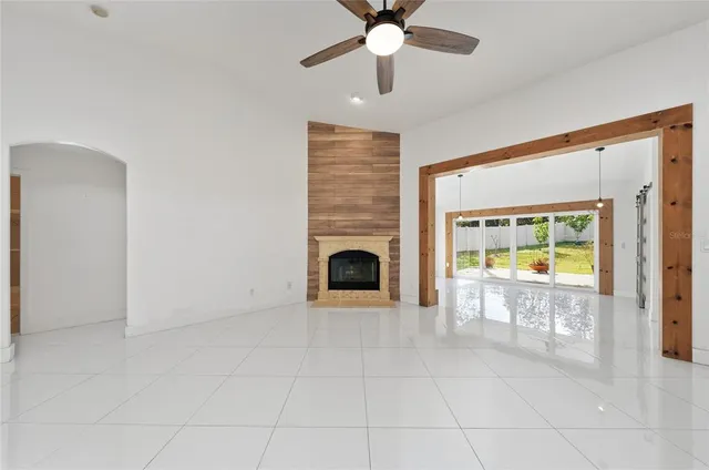 a view of an empty room with a fireplace and a window