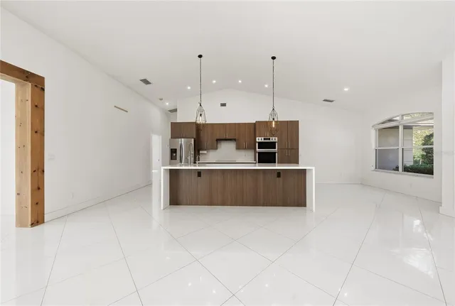 a large kitchen with a stove a sink a microwave and a refrigerator