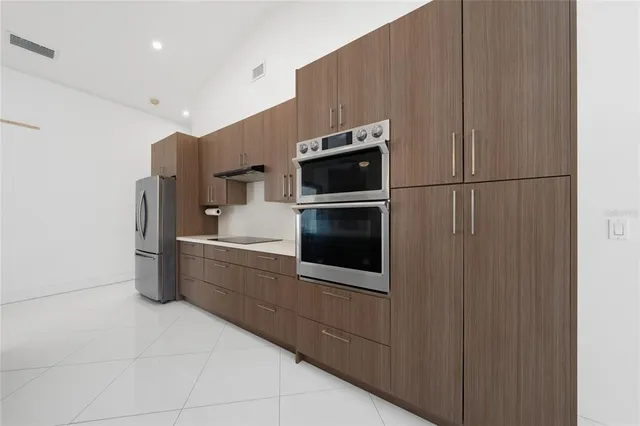 a kitchen with stainless steel appliances a refrigerator and a stove top oven