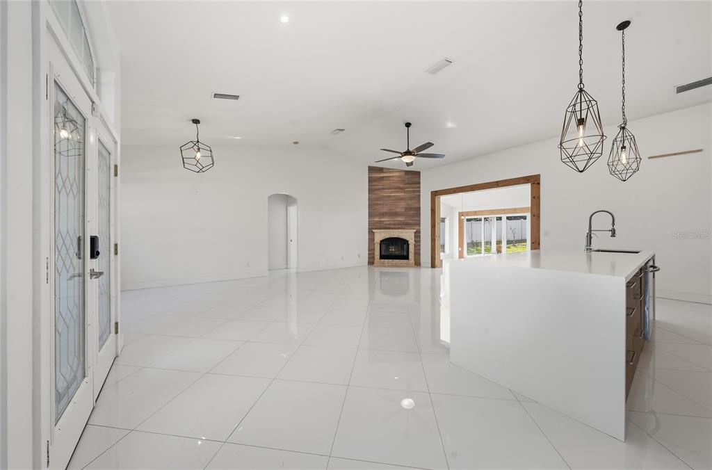 11036 Bronson Road Clermont, FL 34711 - Photo 6 of 29 a view of an empty room with chandelier fan and kitchen view