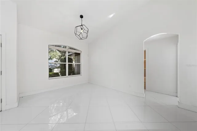 an empty room with windows and ceiling fan