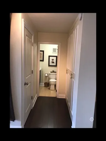 a view of a hallway with a livingroom and a bathroom with a sink
