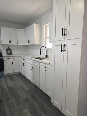 a kitchen with white cabinets sink and dishwasher