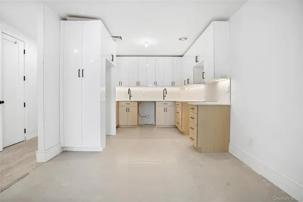 a view of a kitchen with white cabinets