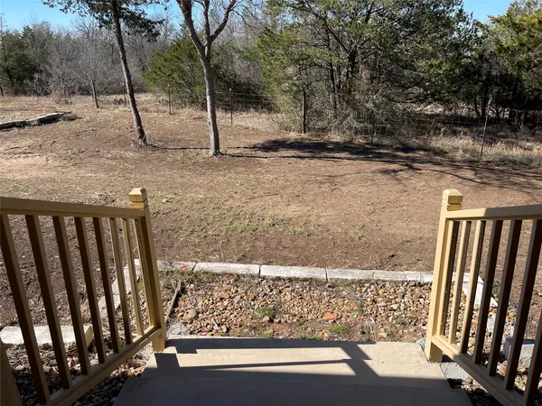 a view of a yard with wooden fence