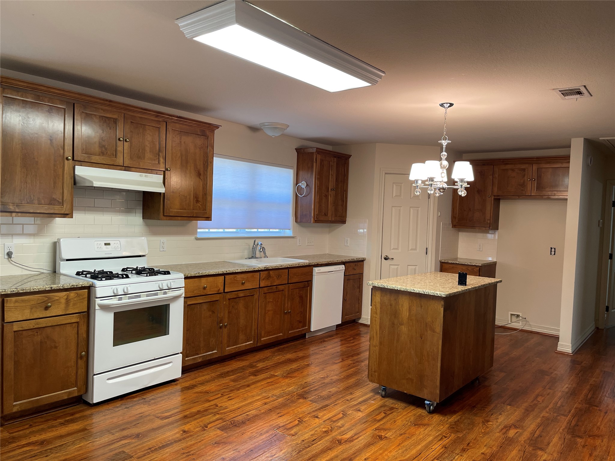 6164 South Fm 535 Road Cedar Creek, TX 78612 - Photo 13 of 27 a kitchen with stainless steel appliances granite countertop wooden floors and white cabinets