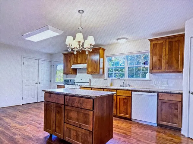a kitchen with a sink cabinets and wooden floor