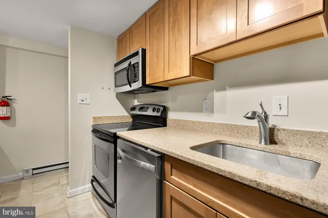 a kitchen with stainless steel appliances granite countertop a sink a refrigerator and a stove