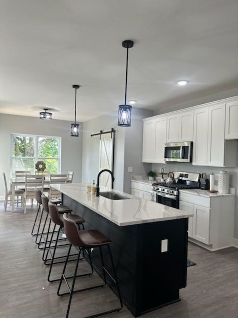 634 Anjali Court, Unit R Sycamore, IL 60178 - Photo 3 of 20 a kitchen with sink cabinets and dining table