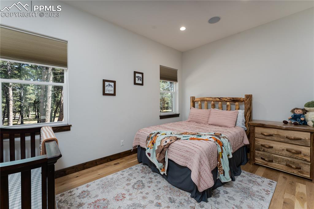 9775 Walker Road Colorado Springs, CO 80908 - Photo 17 of 50 a bedroom with a bed a dresser and a large window