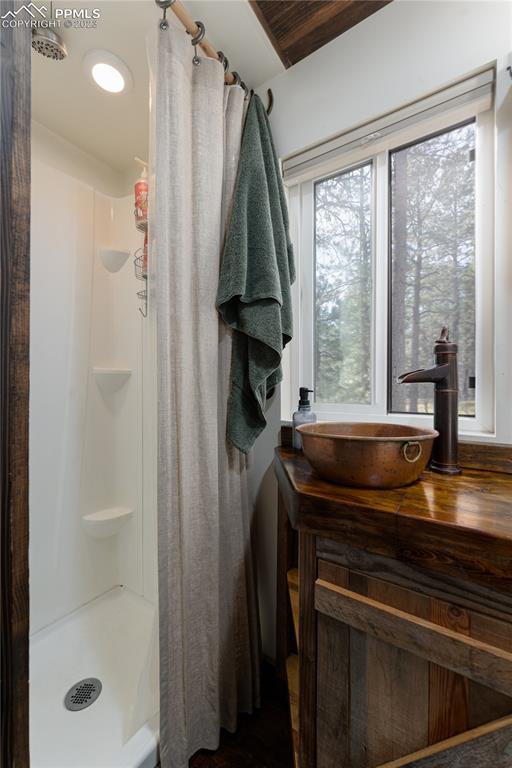9775 Walker Road Colorado Springs, CO 80908 - Photo 35 of 50 a bathroom with a granite countertop sink a mirror and shower