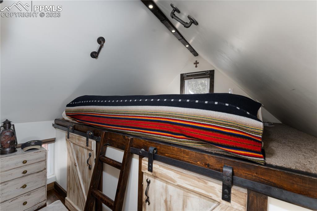 9775 Walker Road Colorado Springs, CO 80908 - Photo 37 of 50 a bedroom with a bed and cabinets