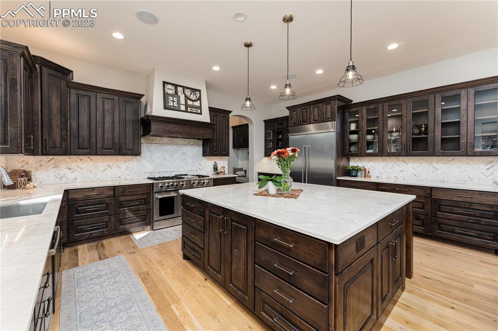 9775 Walker Road Colorado Springs, CO 80908 - Photo 9 of 50 a kitchen that has a lot of cabinets in it and wooden floors