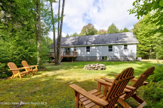a view of a house with pool and chairs