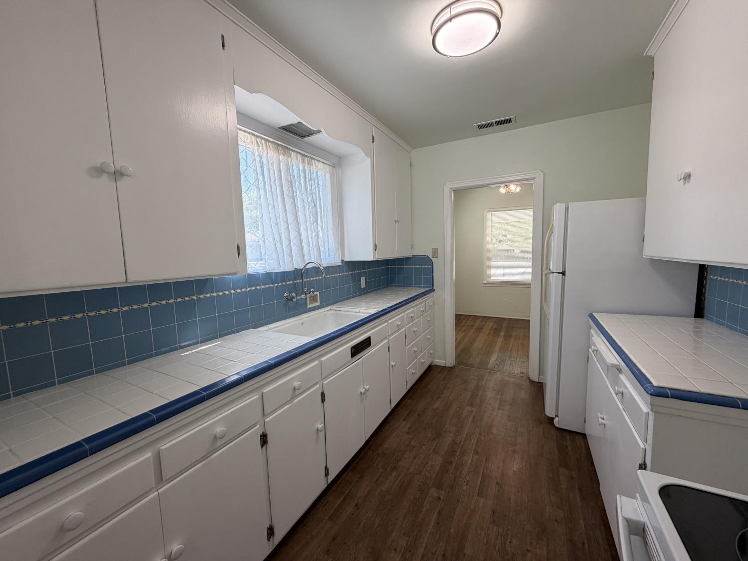 713 West 4th Street Madera, CA 93637 - Photo 16 of 28 a large kitchen with a sink and dishwasher a stove with wooden floor