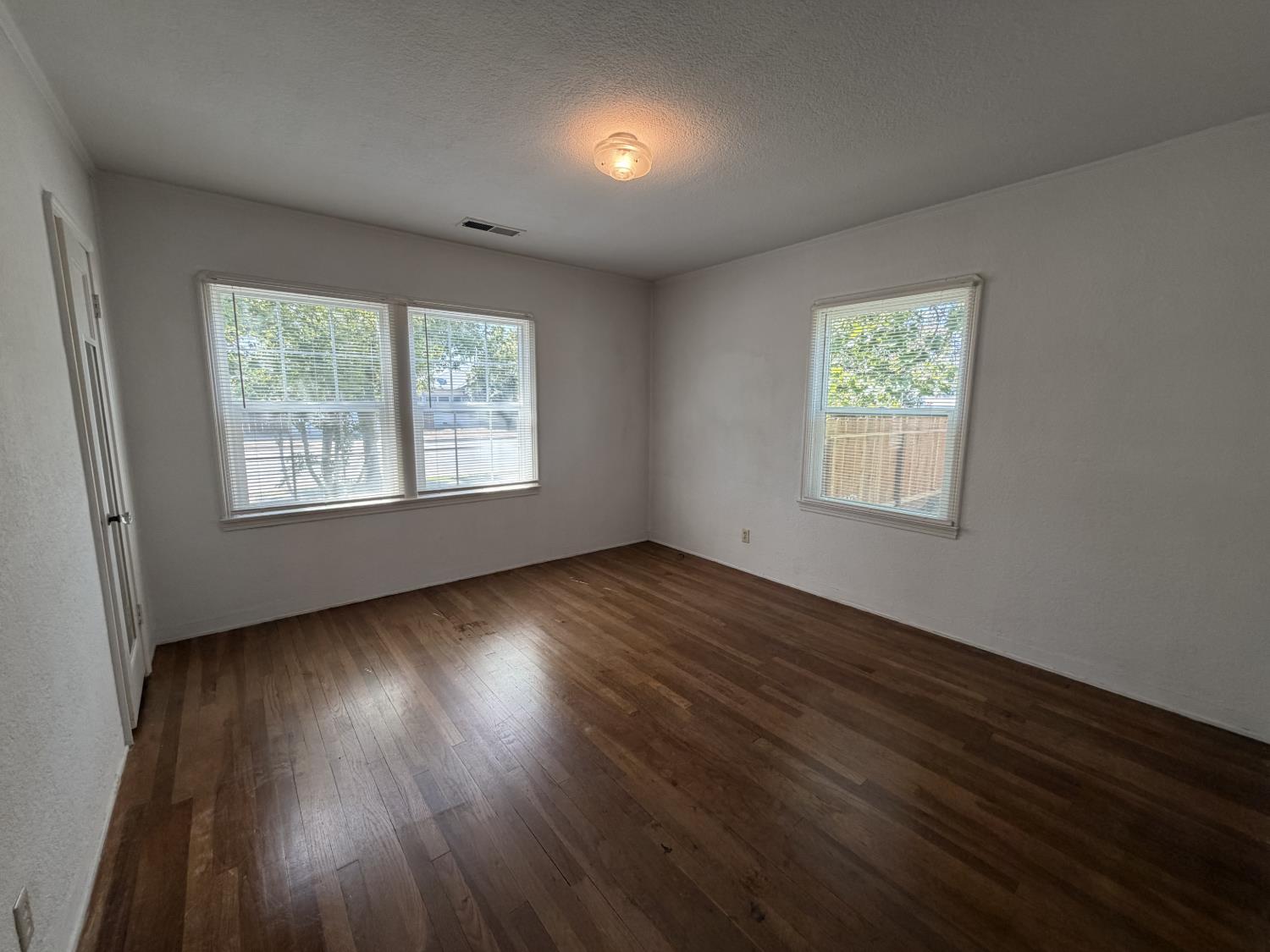 713 West 4th Street Madera, CA 93637 - Photo 17 of 28 an empty room with wooden floor and windows