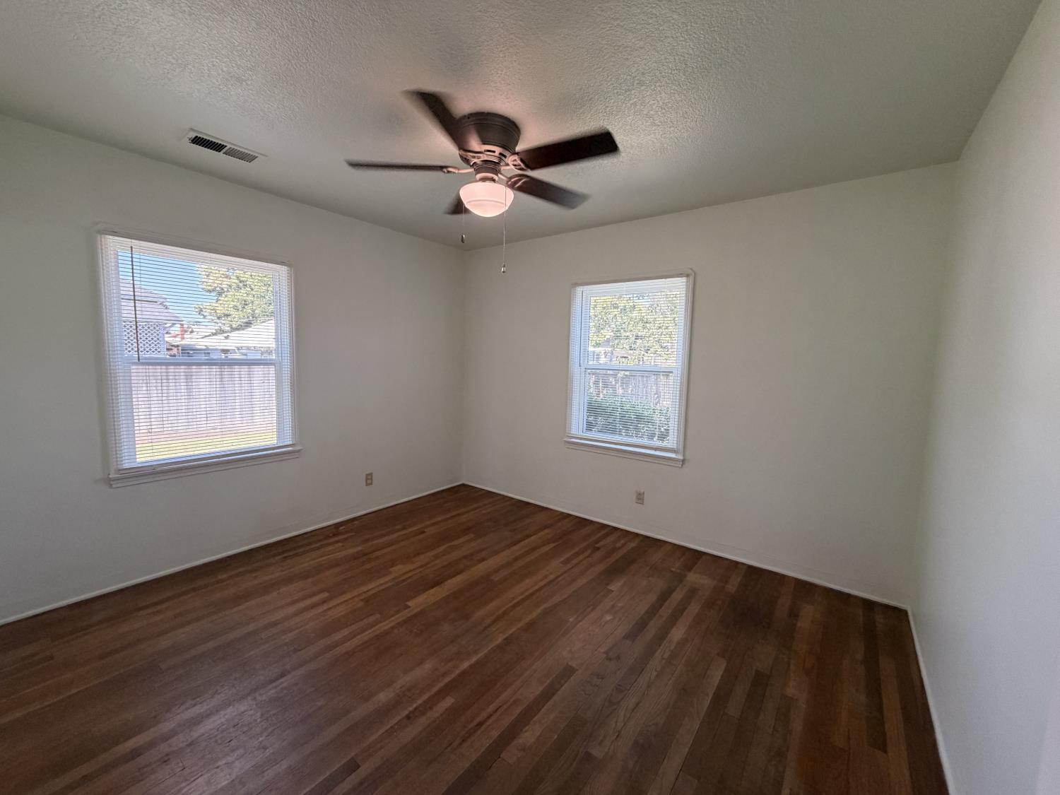 713 West 4th Street Madera, CA 93637 - Photo 19 of 28 a view of an empty room with wooden floor and a window