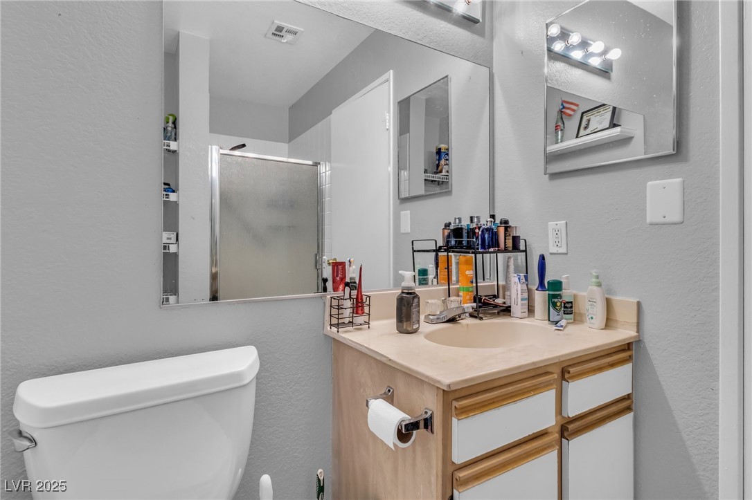 2200 South Fort Apache Road, Unit 1007 Las Vegas, NV 89117 - Photo 20 of 30 Full bathroom featuring a stall shower, visible vents, vanity, and toilet