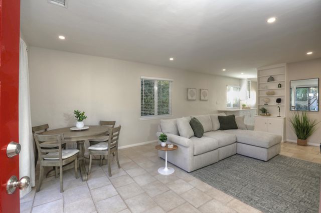 a living room with furniture a dining table and a potted plant