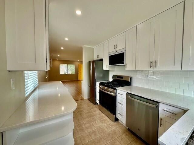 a kitchen with stainless steel appliances granite countertop a stove a sink and a refrigerator