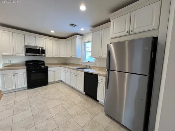 a kitchen with stainless steel appliances granite countertop a refrigerator sink and cabinets