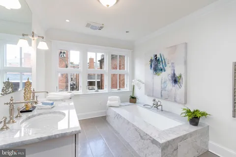 a bathroom with a granite countertop sink and a large mirror