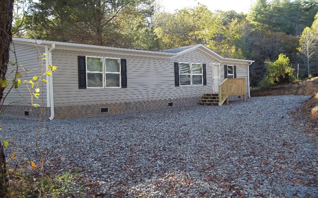 a view of house with a yard and a large tree