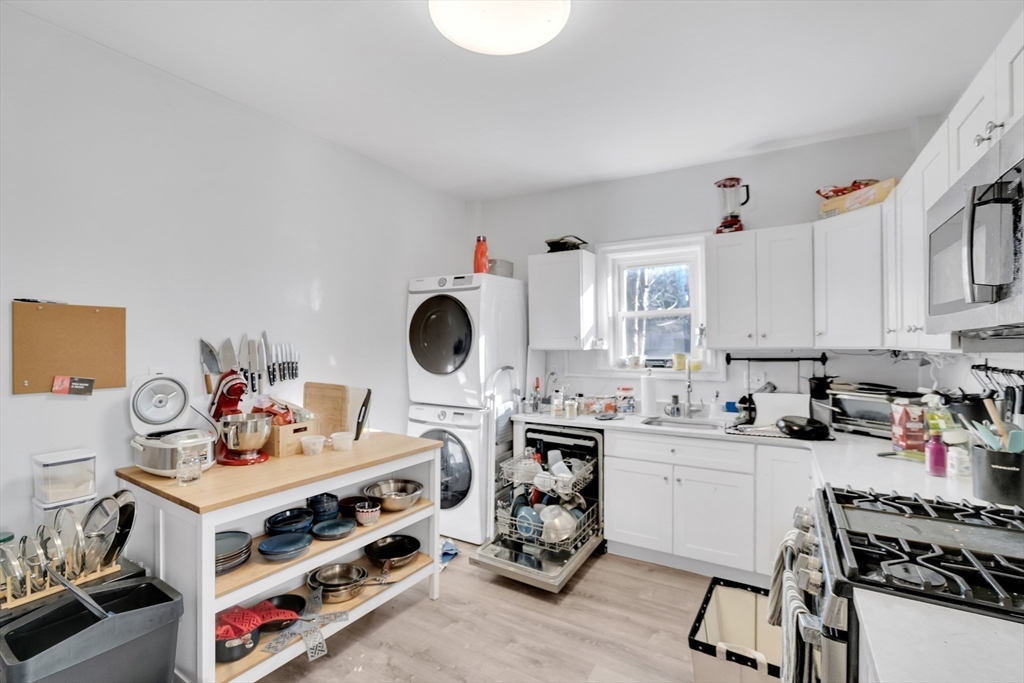 39 Union Street Boston, MA 02135 - Photo 6 of 27 a kitchen with a sink a stove and white cabinets