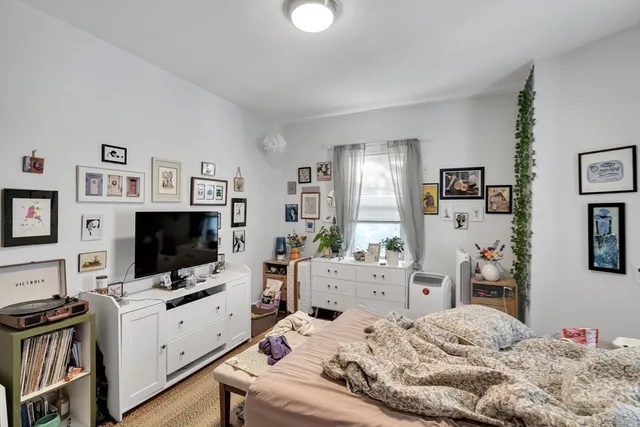 a bedroom with a flat screen tv on the dresser and a flat screen tv