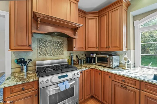 a kitchen with stainless steel appliances granite countertop a stove a sink and a microwave