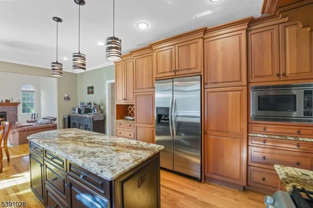 a kitchen with granite countertop stainless steel appliances a refrigerator a stove a sink and cabinets