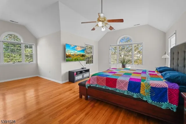 a bedroom with a bed chandelier and a window