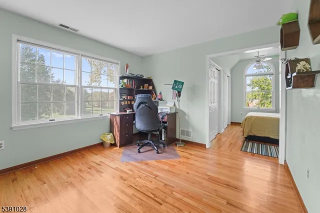 a view of a workspace with furniture and a window