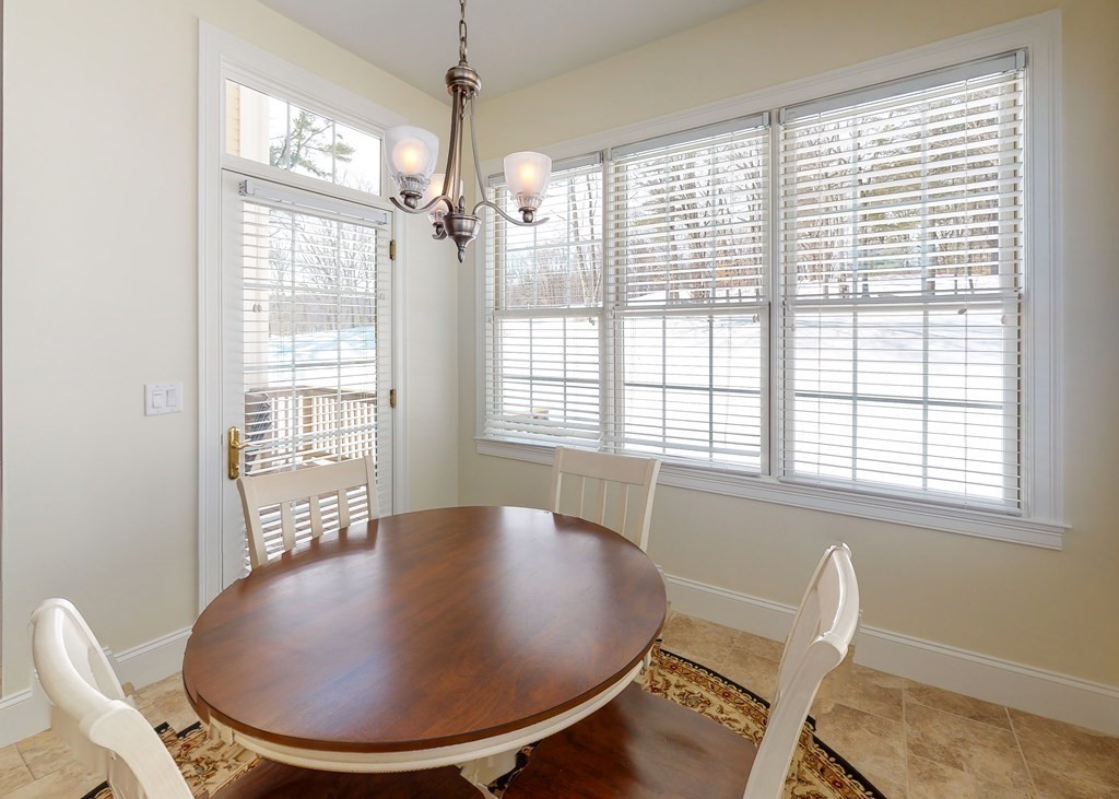 80 Clubhouse Way, Unit 80 Sutton, MA 01590 - Photo 14 of 29 a view of a dining room with furniture wooden floor and chandelier
