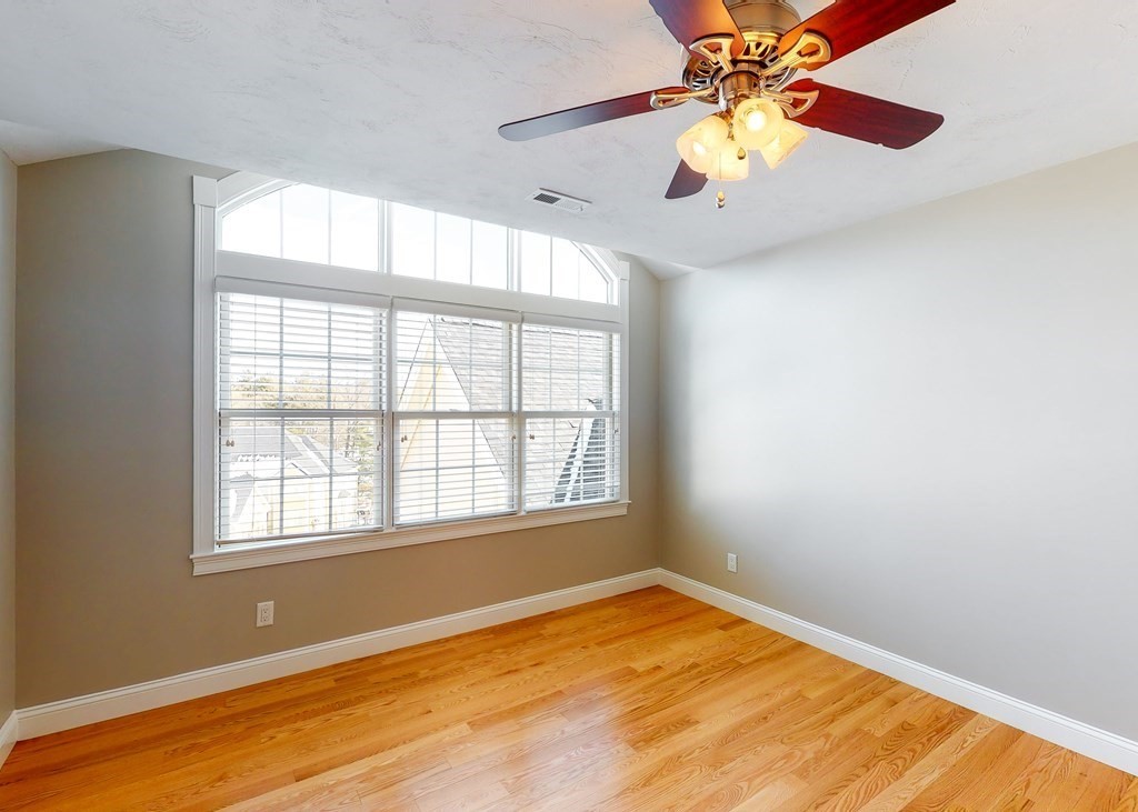 80 Clubhouse Way, Unit 80 Sutton, MA 01590 - Photo 16 of 29 a view of an empty room with window and chandelier fan