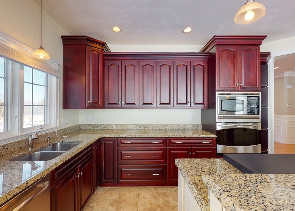 80 Clubhouse Way, Unit 80 Sutton, MA 01590 - Photo 7 of 29 a kitchen with granite countertop wooden cabinets a sink and dishwasher