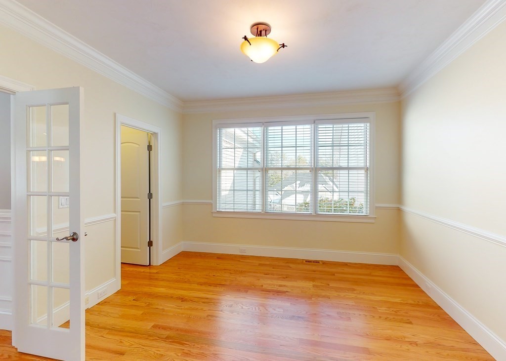 80 Clubhouse Way, Unit 80 Sutton, MA 01590 - Photo 10 of 29 a view of an empty room with wooden floor and a window