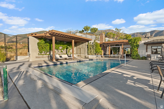 912 North Loafer Canyon Road Elk Ridge, UT 84651 - Photo 60 of 98 Swimming pool with integrated volleyball net, expansive concrete decking, and an adjacent wood pergola