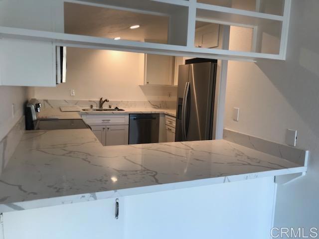 527 South Sierra Avenue, Unit 185 Solana Beach, CA 92075 - Photo 13 of 30 a kitchen with stainless steel appliances granite countertop a sink a stove and a refrigerator