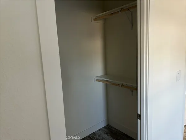 an empty room with wooden floor and closet