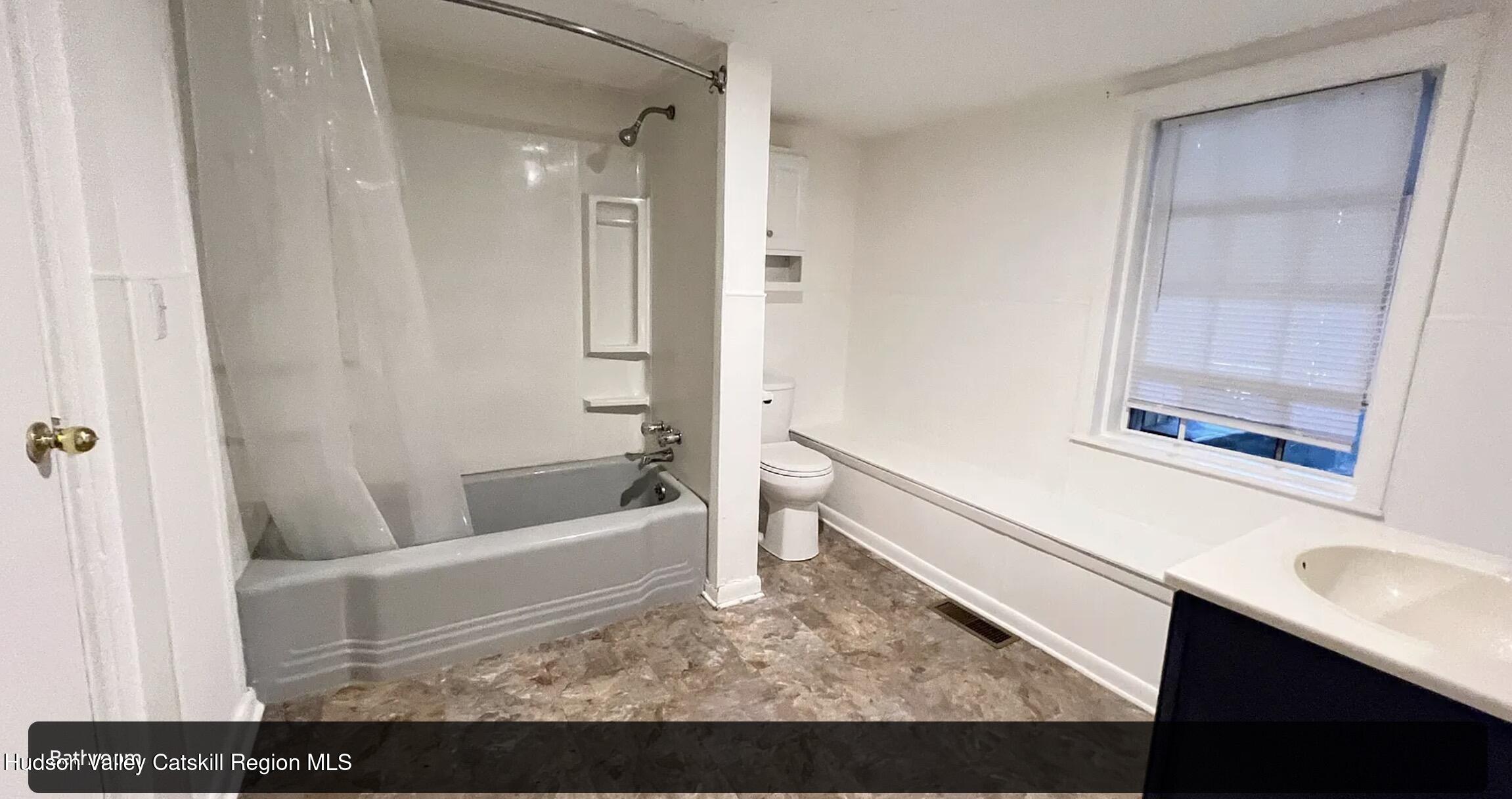 602 Columbia Street, Unit 1 Hudson, NY 12534 - Photo 15 of 19 a bathroom with a bathtub a sink and a window