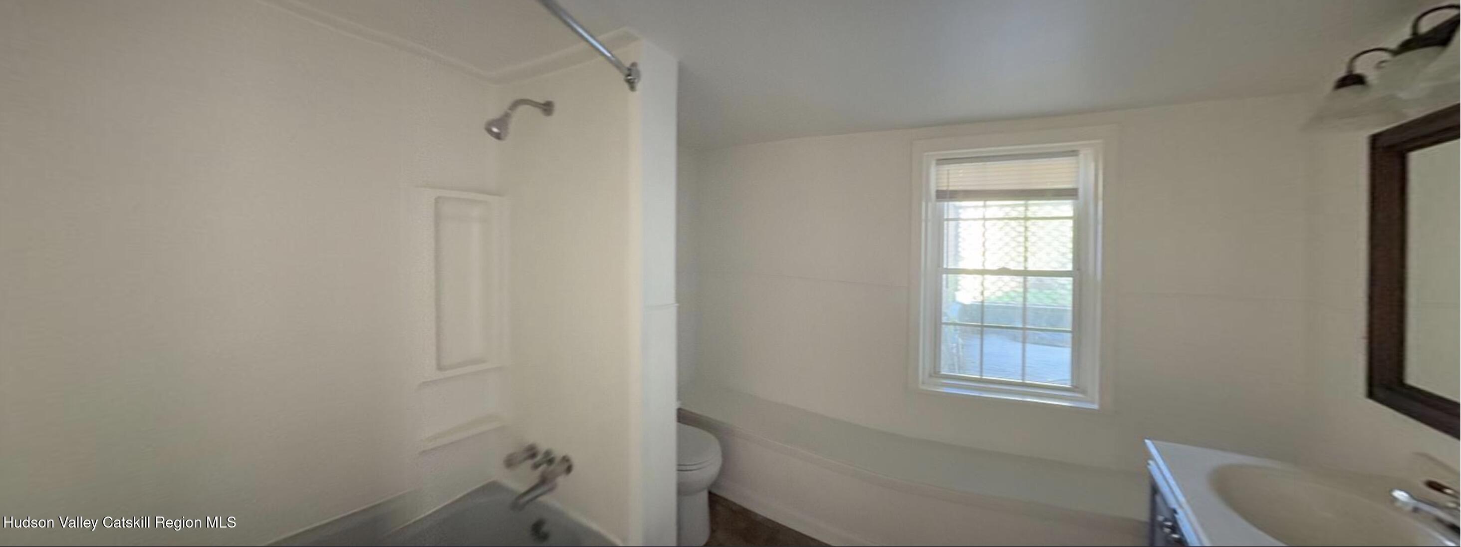 602 Columbia Street, Unit 1 Hudson, NY 12534 - Photo 16 of 19 a bathroom with a window and a toilet