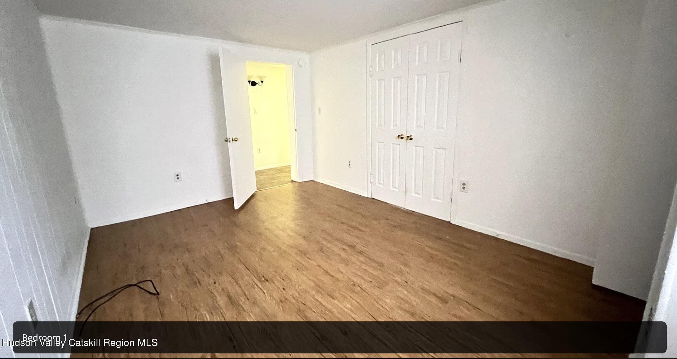 602 Columbia Street, Unit 1 Hudson, NY 12534 - Photo 8 of 19 an empty room with wooden floor and closet