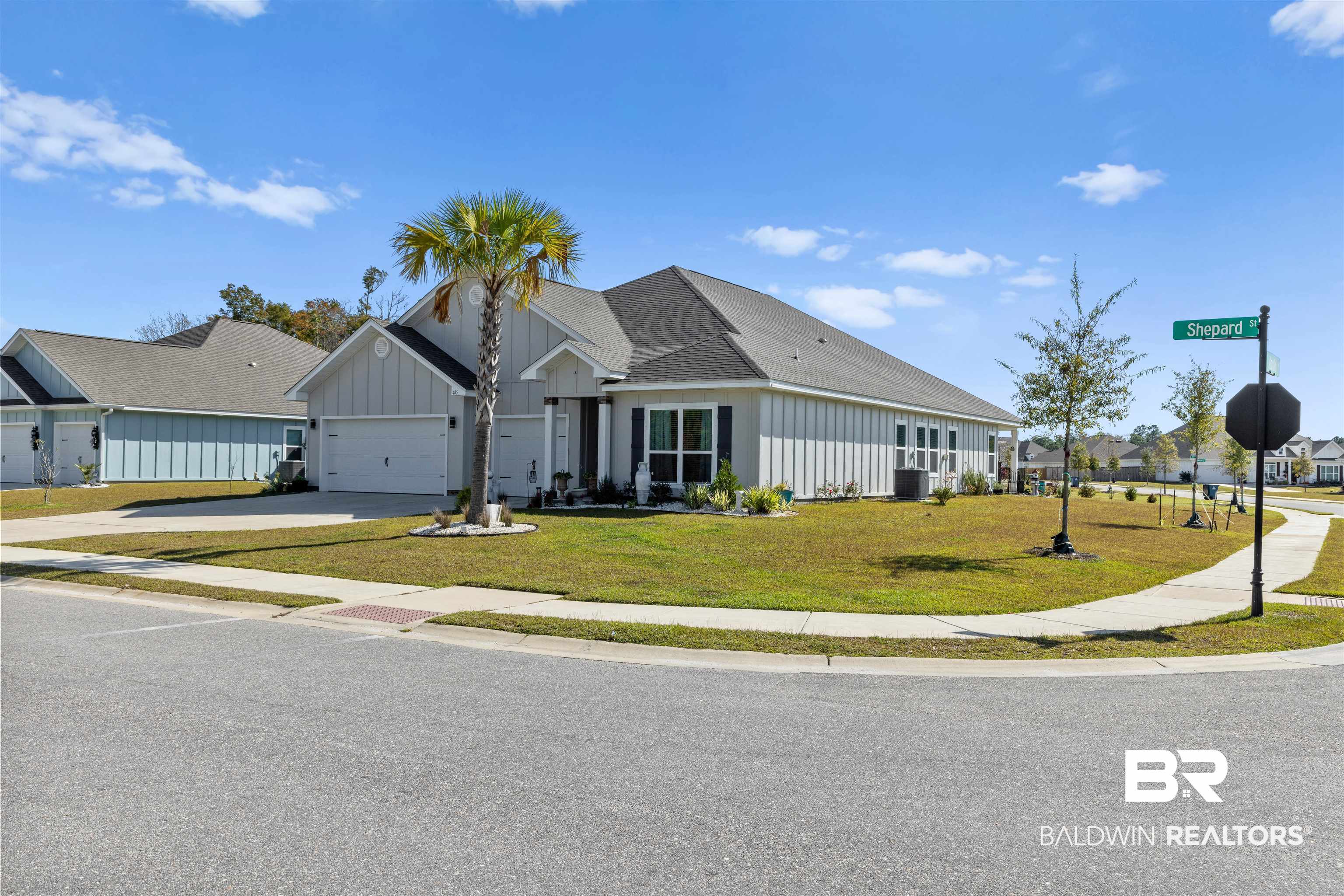 485 Shepard Street Gulf Shores, AL 36542 - Photo 4 of 53 View of front of home featuring board and batten siding, concrete driveway, a front lawn, and a garage