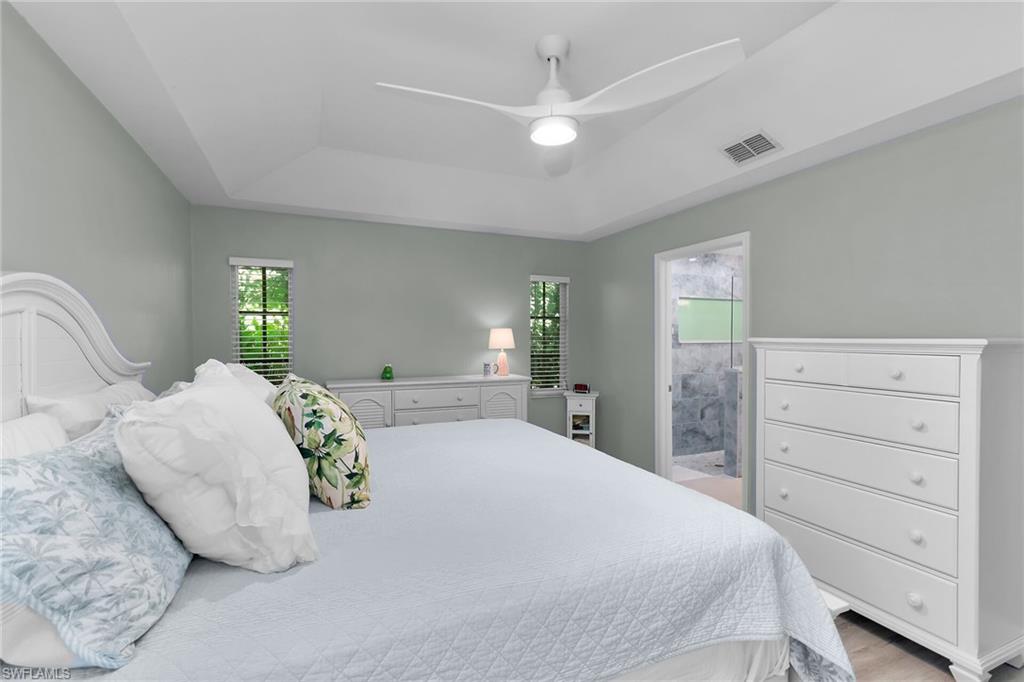 789 Coldstream Court Naples, FL 34104 - Photo 15 of 26 a bedroom with a large bed and a dresser
