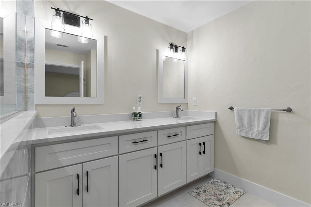 789 Coldstream Court Naples, FL 34104 - Photo 17 of 26 a bathroom with a double vanity sink and mirror