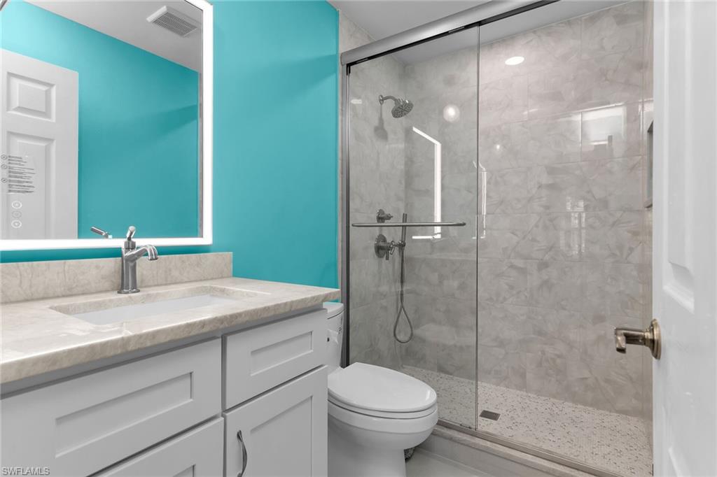789 Coldstream Court Naples, FL 34104 - Photo 20 of 26 a bathroom with a granite countertop sink toilet and shower