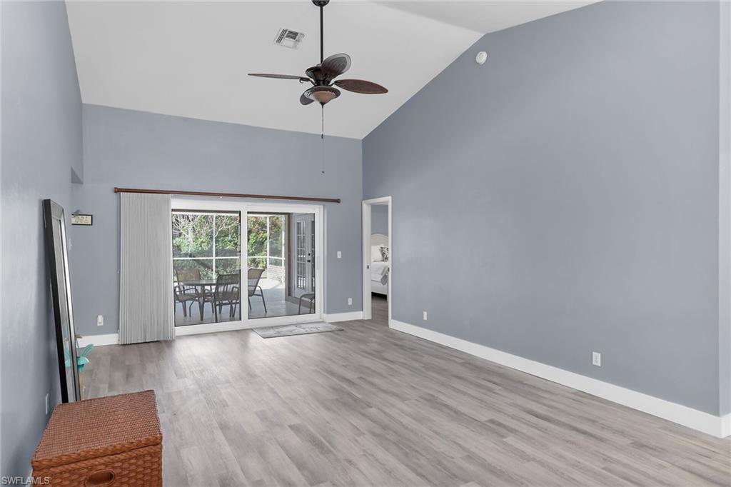 789 Coldstream Court Naples, FL 34104 - Photo 4 of 26 a view of an empty room with a window and wooden floor