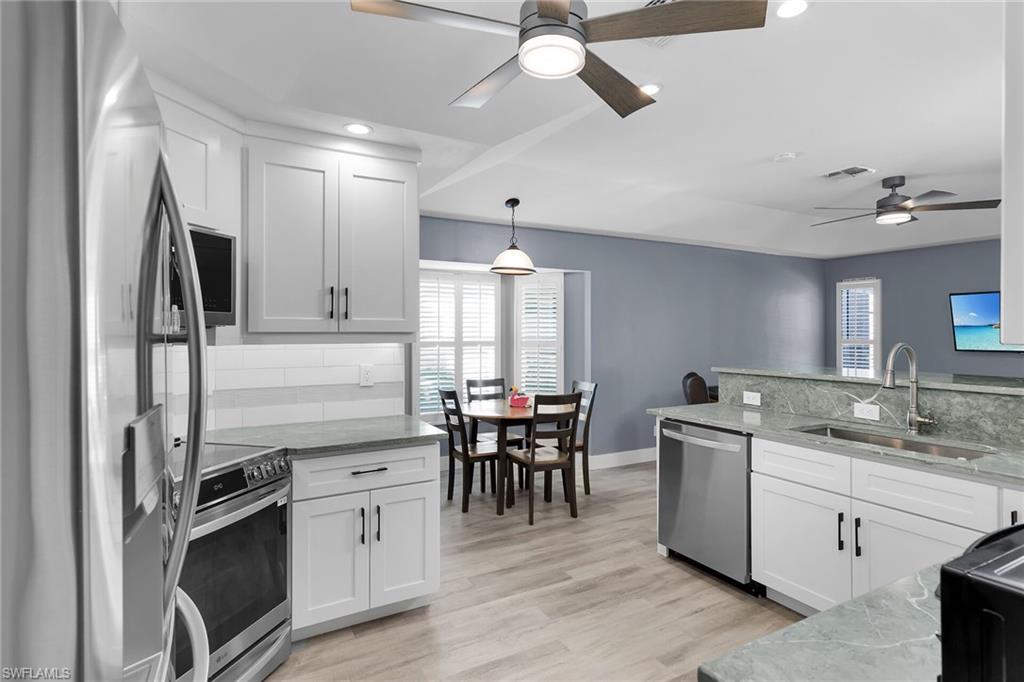 789 Coldstream Court Naples, FL 34104 - Photo 7 of 26 a kitchen with stainless steel appliances granite countertop a sink stove and refrigerator