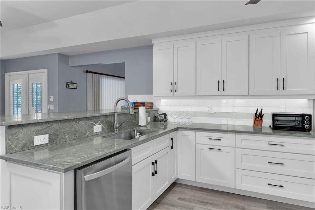 789 Coldstream Court Naples, FL 34104 - Photo 8 of 26 a kitchen with granite countertop white cabinets and white appliances